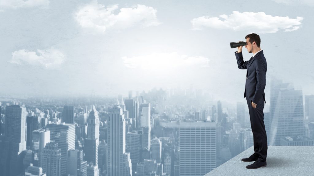 Man looking forward from the top of a skyscraper